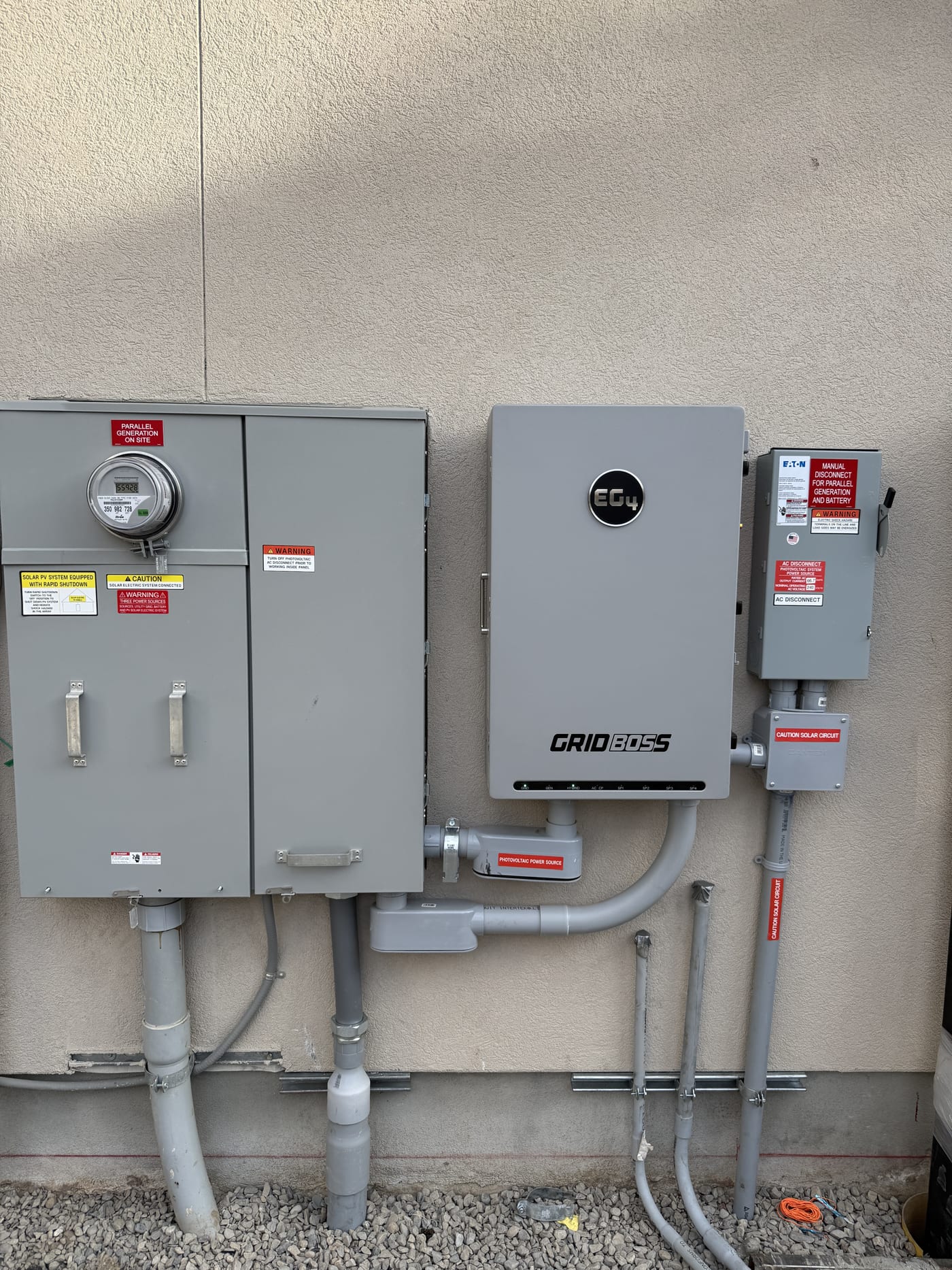 Full EG4 GridBOSS inverter setup with meter electrical panels disconnects and conduit on exterior wall