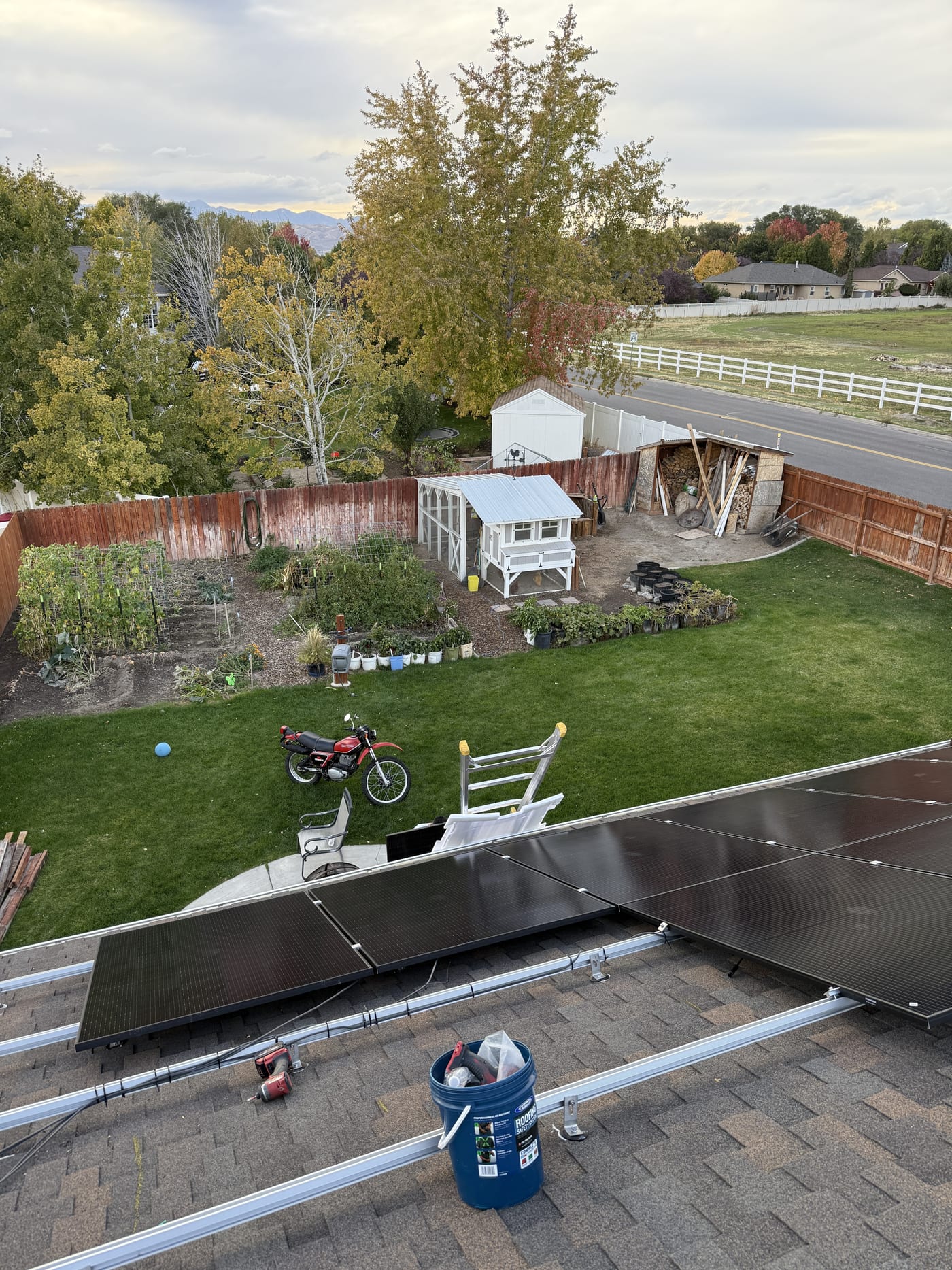 [Trina panels] Solar panels on roof overlooking backyard with shed and green lawn