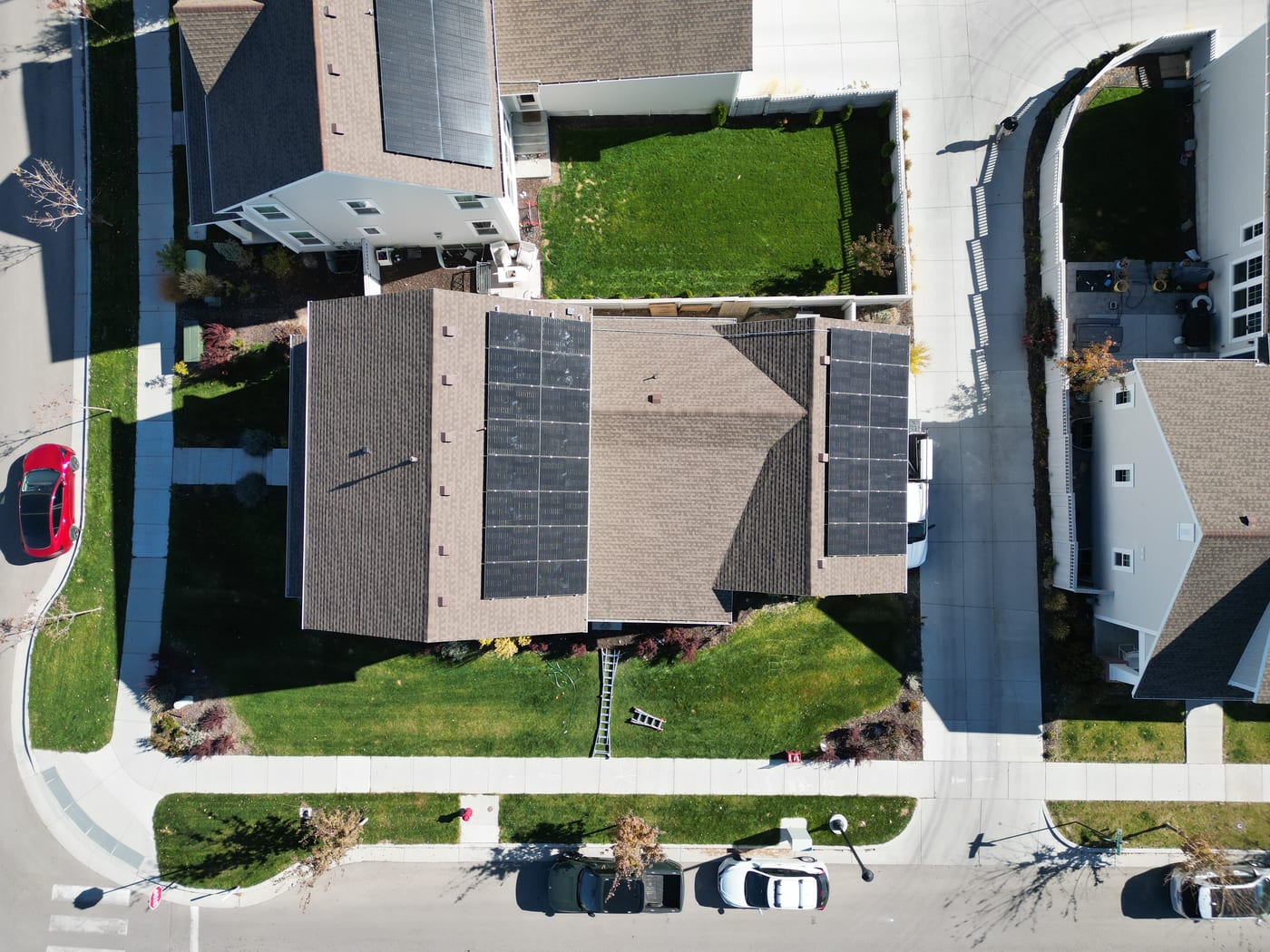 Drone aerial of house with completed solar array showing full neighborhood context in South Jordan
