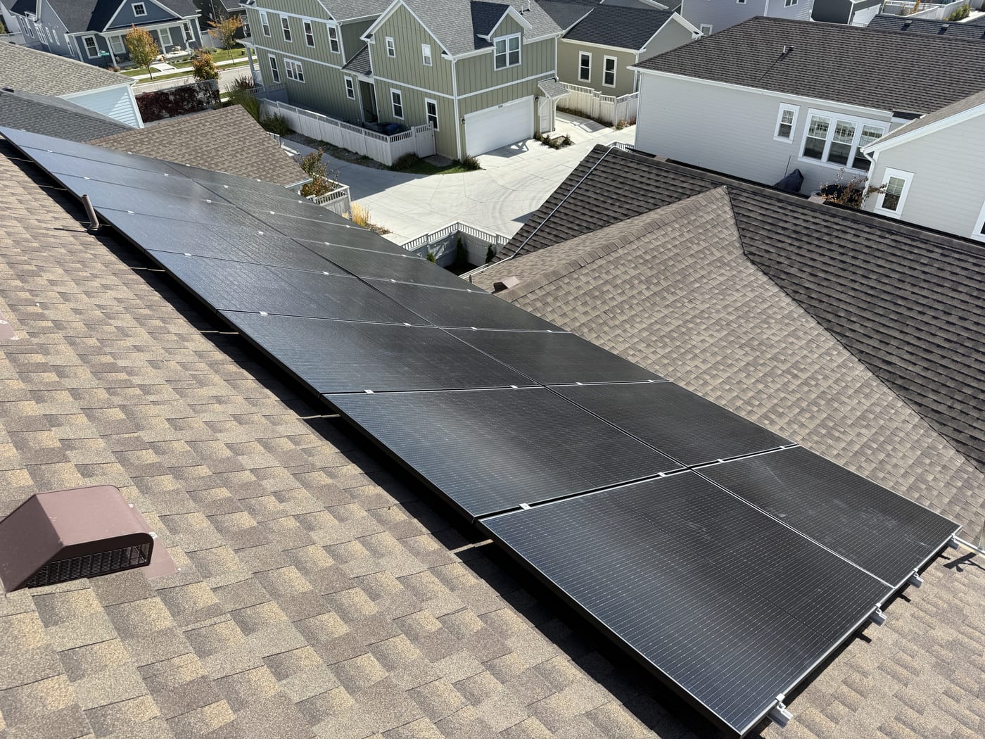 Large solar panel array on roof looking down to suburban South Jordan neighborhood