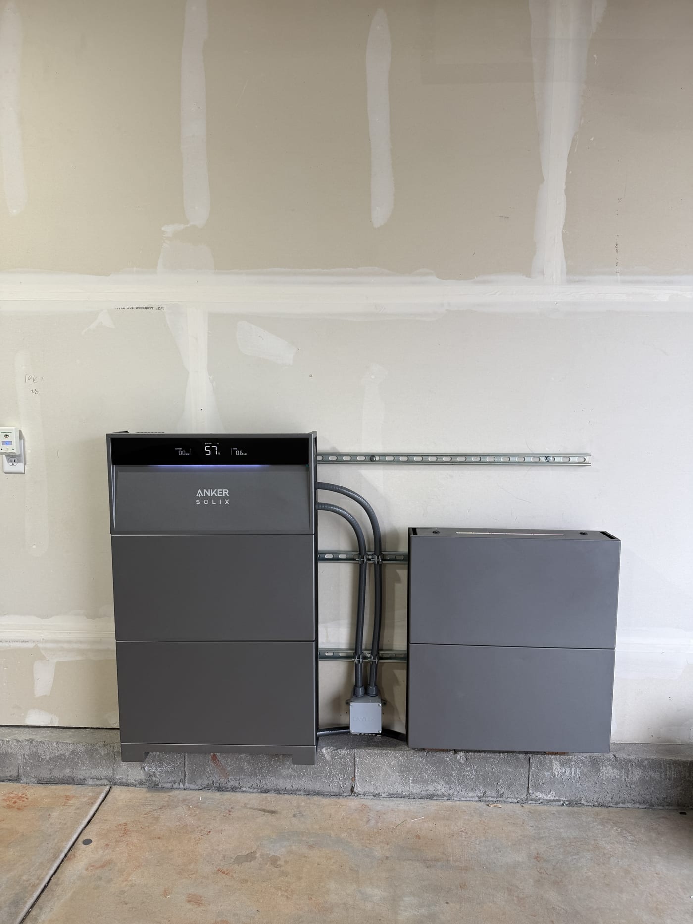 Wider view of Anker Solix X1 battery system with ANKER SOLIX branding on utility room wall
