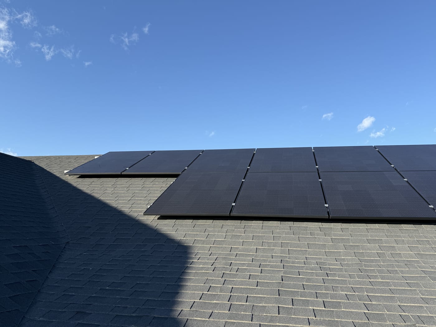 Solar panels on roof edge between roof planes with clear blue sky