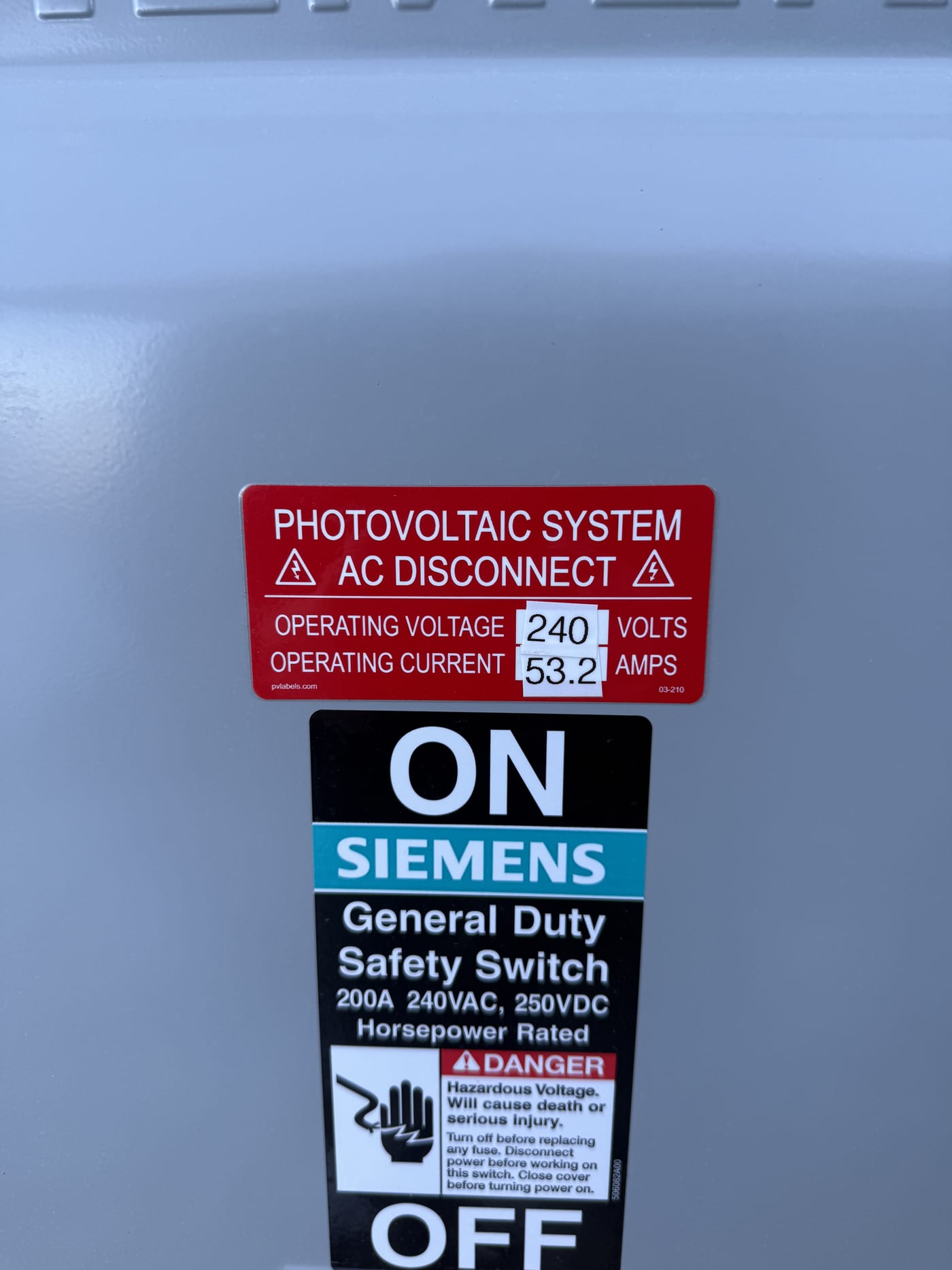 Siemens 200A safety switch with PV AC disconnect label, ON/OFF handle, and parallel generation disconnect sticker