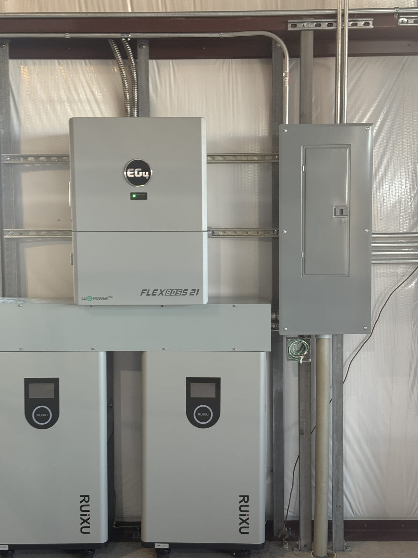 Tight close-up of EG4 FlexBOSS 21 inverter and two RUiXU battery units showing brand logos and displays